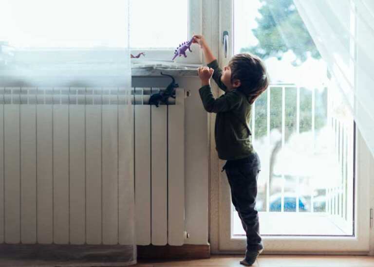 enfant devant radiateur jouant